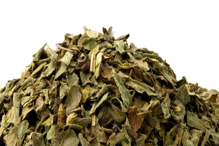 A pile of dried chopped basil isolated on white.